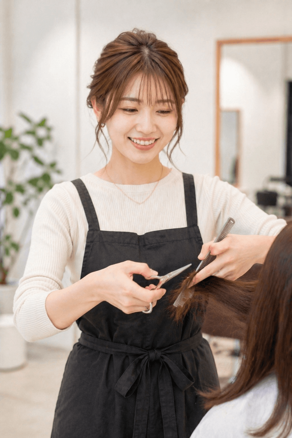 お客様の髪を笑顔で切るスタイリスト